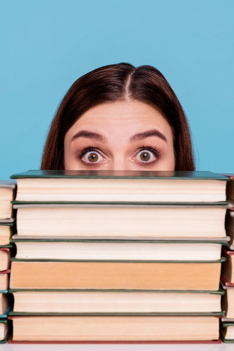 Personne cachée derrière des livres