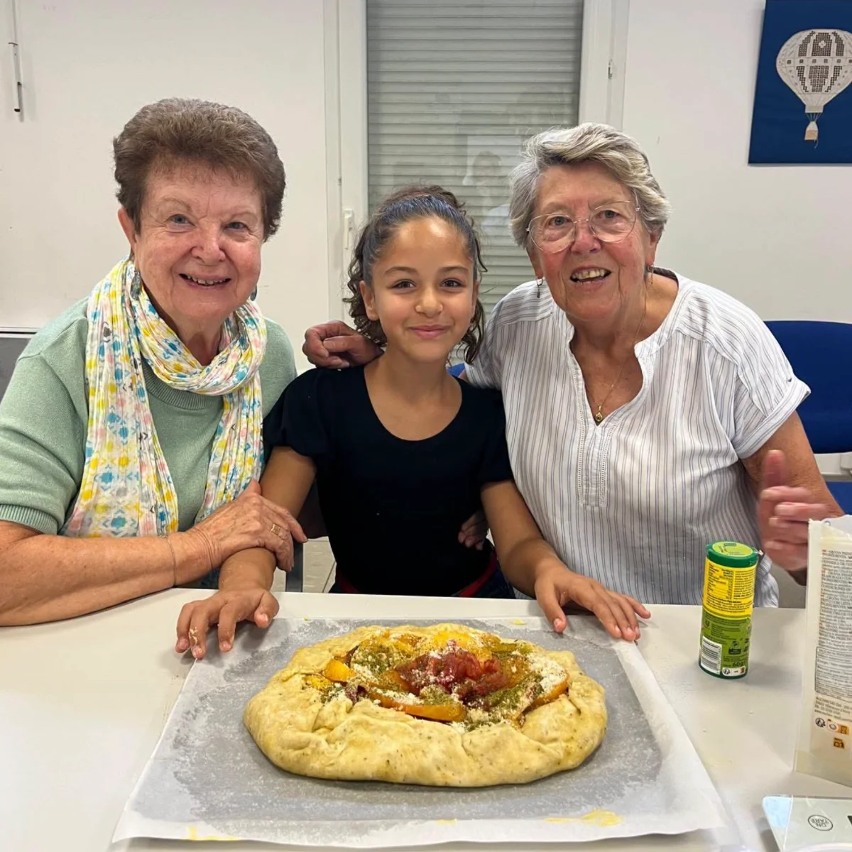 Deux personnes âgées et une petite fille qui présentent leur tarte
