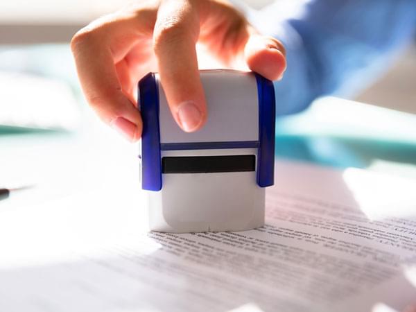 Main s’apprêtant à tamponner un document