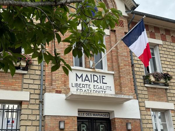 Façade de la Mairie de Buchelay avec les deux drapeaux français et européen et la devise nationale