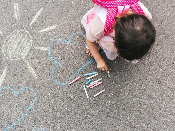 Enfant dessinant à la craie sur le sol