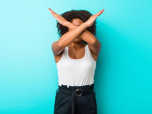 Femme mettant les bras en croix pour dire stop